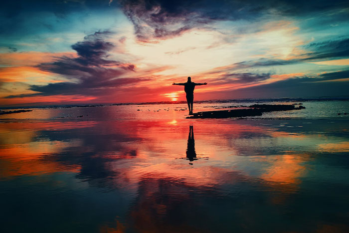 man meditating in the sunset