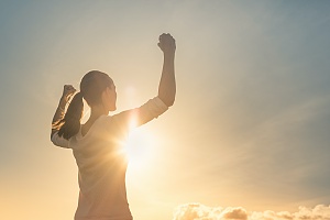 a woman lifting up her arms because she is empowered in her recovery program's process