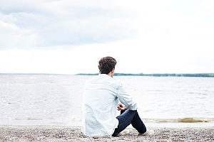 man sitting on a beach contemplating how to deal with his co-occuring disorder