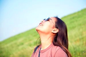 woman wearing sunglasses staring up at the sky