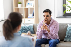patient in alcohol rehab holds water and listens to therapist
