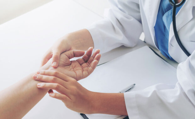 doctor examining the patients pulse by hands