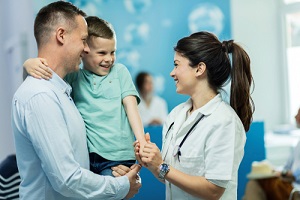 nurse holding hands and communicating with small boy