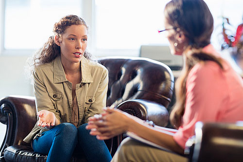 a woman speaking to a therapist in cognitive behavioral therapy