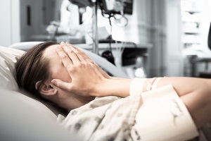 woman patient lying at hospital bed feeling sad and depressed worried
