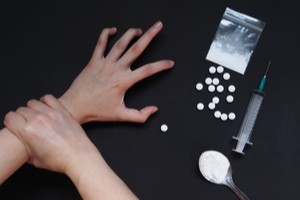 Hand stopping another hand from taking drug pills powder and injection