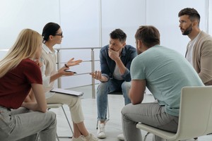 Group of rehab patients talking with therapist