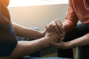 Two men holding each other's hands in a way that indicates confidence