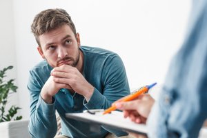 A man is consulting the Aquila Recovery Center therapist for aftercare programs