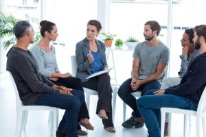 An IOP therapist is having a conversation with the group