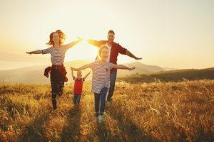 Family of four enjoying a summer evening in the grass field