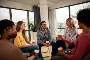 Five people talking to one another in an IOP support group