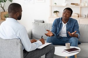 A man in an outpatient program with a male therapist