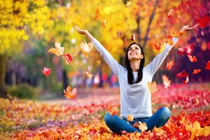 A woman enjoying nature in the park full of maple tree leaves