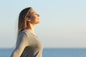 A woman feeling sunlight with joy