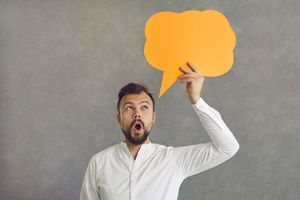 Man holding orange thought bubble indicating positive thinking