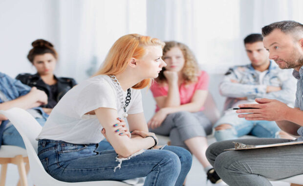 A group therapist talking to a girl