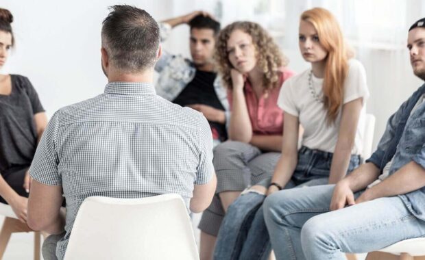 group of young people talking with psychologist in the rehab center