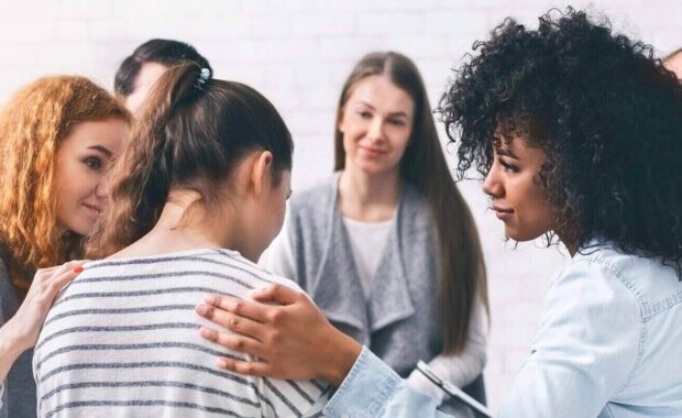 support group patients comforting woman at therapy session