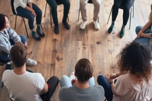 the gathering features several people seated in a circle for DC outpatient treatment program