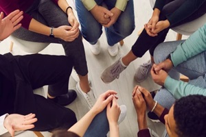 view of diverse people sitting in a close circle and talking to a therapist