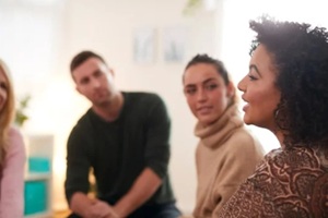 Woman Speaking At Support Group Meeting For Mental Health Or Dependency Issues In Community Space