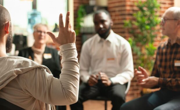 selective focus on young guy making gestures with his hand during Intensive Outpatient Programs therapy