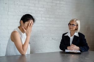 Emotional Woman with Hand on Face in Front of a Therapist