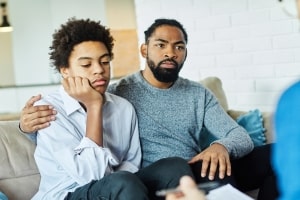 Father with His Sad Teenage Son in A Therapy Session