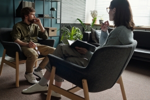 Man Talking to Woman Therapist During Mental Health Assessment