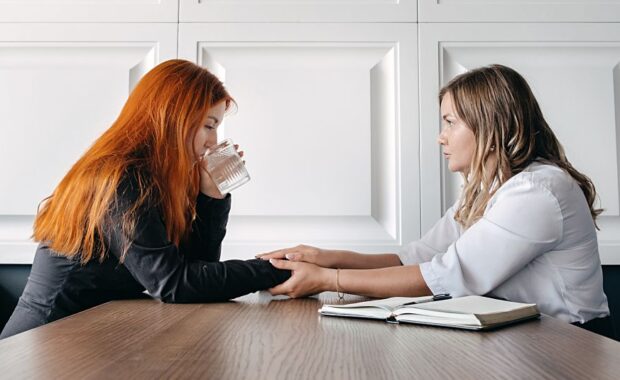 Women Sitting on A Couch Talking to Female Therapist about His Childhood Trauma