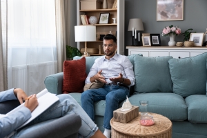 Young Patient Explaining His Problems to Therapist in Session