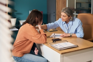 Psychologist Comforting Sad Woman with Care During Therapy Session in Her Office