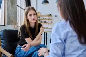 Stressed Young Woman in Therapy Program with Psychologist