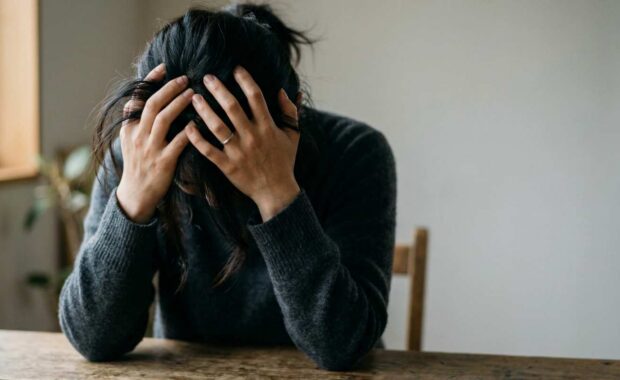 Woman Struggling with Emotional Stress Sitting at Table